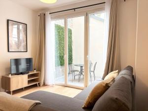 un salon avec un canapé et une télévision dans l'établissement Grand appartement avec terrasse - 4 voyageurs, à Roubaix