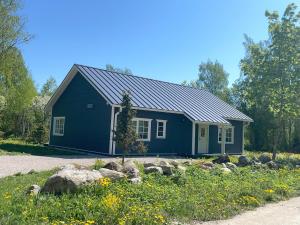 a blue house with rocks in front of it at Kopli puhkemaja Saaremaal in Kasti