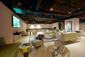 ドーハにあるSteigenberger Residence Dohaのリビングルーム(ソファ、椅子、テレビ付)