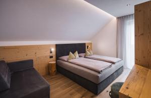 a bedroom with a bed and a couch at Obermairhof in Valdaora di Sotto