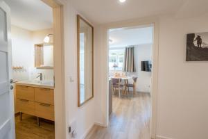 a kitchen with a sink and a mirror and a table at Landhaus Ohrwumslar in Oberstdorf +59 photos