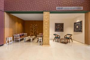 a room with chairs and tables and paintings on the wall at Sterling Rudraksh Jaisalmer in Jaisalmer
