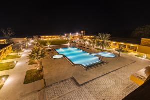 an outdoor swimming pool at night with palm trees at Sterling Rudraksh Jaisalmer in Jaisalmer