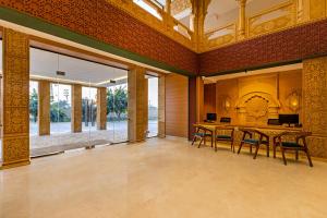 a dining room with a table and chairs and windows at Sterling Rudraksh Jaisalmer in Jaisalmer