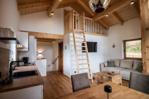 a kitchen and living room with a ladder in a tiny house at Ferienhäuser Koralpe unicorn village in Wolfsberg