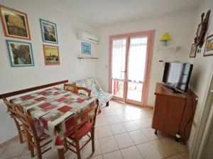 a living room with a table and a tv at Lara in Rosolina