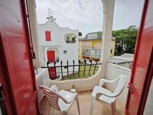 a balcony with chairs and a view of a building at Lara in Rosolina