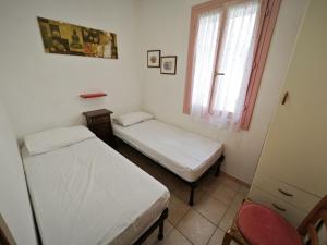 two beds in a small room with a window at Lara in Rosolina