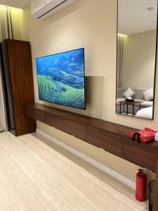 a living room with a flat screen tv on a wall at Studio Sulimaniyah in Riyadh