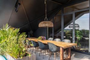an outdoor dining room with a wooden table and chairs at Enjoy Heaven in Schellinkhout