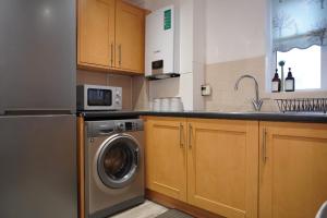 NEW 2-Bedroom - Parking - Ideal4Family في Harold Wood: مطبخ مع غسالة ومغسلة