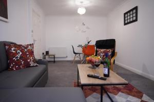 NEW 2-Bedroom - Parking - Ideal4Family في Harold Wood: غرفة معيشة بها أريكة وطاولة