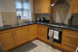 NEW 2-Bedroom - Parking - Ideal4Family في Harold Wood: مطبخ مع خزائن خشبية ومغسلة +13 صورة