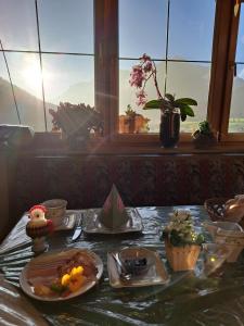 a table with plates of food and a window at Bommerhof in Waidring