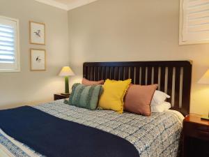 a bedroom with a bed with colorful pillows on it at The Loft in Kiepersol