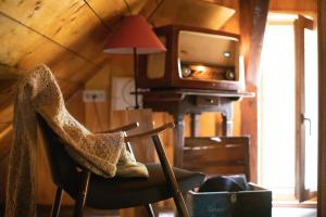 a living room with a chair and a tv at HIS-a za 2 in Dragatuš