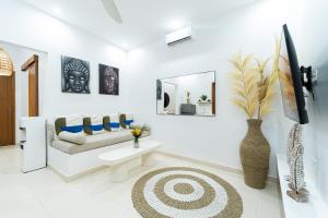 a white living room with a couch and a mirror at Salthouse Villa Uluwatu in Uluwatu