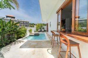 an outdoor patio with a pool and a table and chairs at Salthouse Villa Uluwatu in Uluwatu