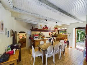 a kitchen with a table and chairs in a room at Séjour authentique-Piscine Privée Chauffée- Spa et Nature in Beauville