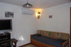 a living room with a couch and a flat screen tv at DOMAINE LE PLA de LIÉRE in Maury