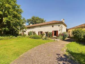 an old house with a grass yard in front of it at Séjour authentique-Piscine Privée Chauffée- Spa et Nature in Beauville