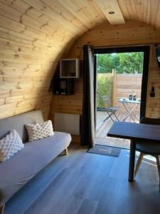 a living room with a couch and a table at A l ombre des pods Chardonnay et spa in Saint-Hilaire