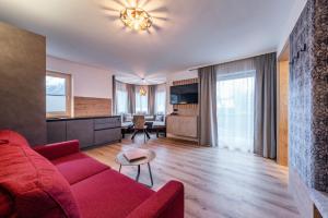 salon z czerwoną kanapą i stołem w obiekcie Montana Apartments w Mayrhofen