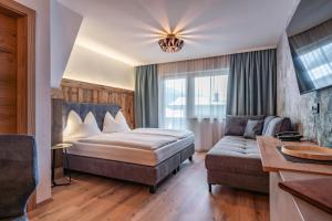 pokój hotelowy z łóżkiem i kanapą w obiekcie Montana Apartments w Mayrhofen