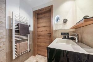 Łazienka z umywalką i drewnianymi drzwiami w obiekcie Montana Apartments w Mayrhofen +37 zdjęć