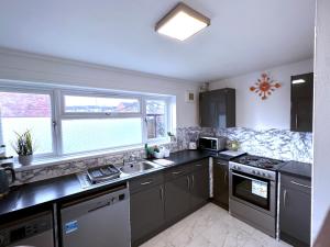 a kitchen with a sink and a stove at Colchester City Luxury With Free Parking and 5 G WIFI in Colchester