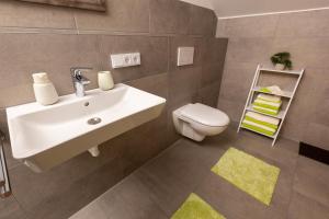 a bathroom with a sink and a toilet at Gaul Lodge - für bis zu 8 Gäste, inkl Königscard, 4 Schlafzimmer, 2 Bäder, große Küche, gratis Parken & WLAN, Self Check-in in Nesselwang +40 photos