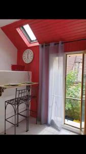 a room with a clock and a table and a window at Studio Indépendant 5 min gare in Nogent-lʼArtaud