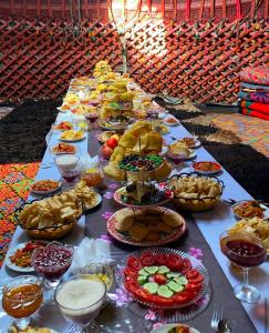 a long table with many plates of food on it at Taasir Yurt Camp in Dzhangyaryk +41 photos