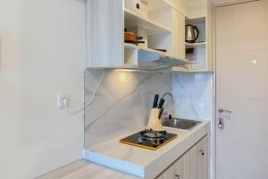 RawalembangCozy and Well Furnished Studio Tokyo Riverside PIK 2 Apartment By Travelio的带水槽和柜台的小厨房