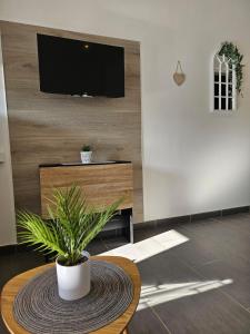 a living room with a table and a tv on a wall at Appart avec terrasse et parking in Audincourt