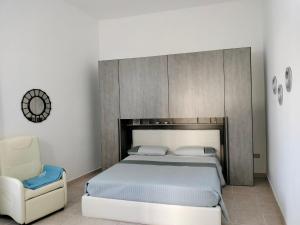 a bedroom with a bed and a chair at La casa nel borgo in Termoli
