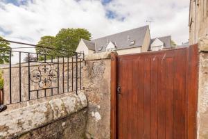 a wooden gate in front of a house at Abbey Villa - No 5 in St. Andrews