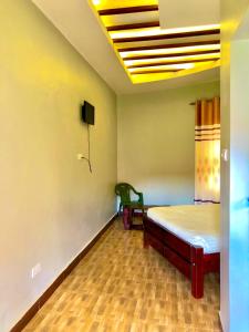 a room with a bed and a tv on the ceiling at JOMRY COTTAGEs in Nsangi