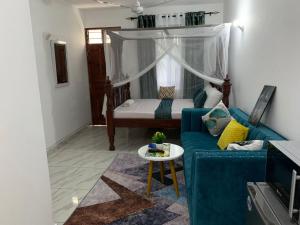 Pazuri Homes في متوابا: غرفة معيشة مع أريكة زرقاء ونافذة