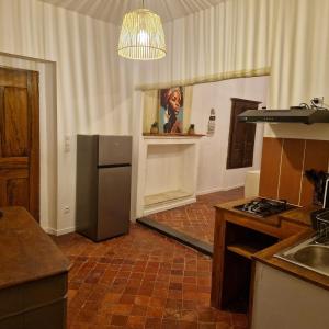 a kitchen with a stainless steel refrigerator and a sink at Appartement centre ville de malaucene in Malaucène