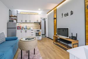 a living room with a blue couch and a kitchen at Top Center in Blagoevgrad