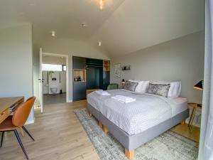 a bedroom with a large bed and a desk and a desk at Magma Hotel in Kirkjubæjarklaustur