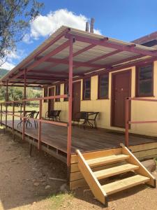 a deck of a house with tables and chairs at Bright Cabin Park in Bright