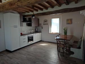 a kitchen with a white refrigerator and a table in it at Al Budri Agriturismo in Roccabianca
