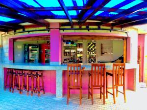 a bar with red stools at a bar at JOMRY COTTAGEs in Nsangi