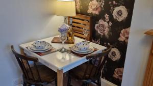 a table with two chairs and a table with plates and glasses at Haven Retreat at Hillrise in Herne Bay