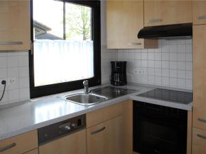 une cuisine avec un évier et une fenêtre dans l'établissement Ferienhaus Nr 70, Kategorie Komfort, Feriendorf Hochbergle, Allgäu, à Bichel