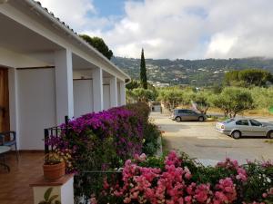 a building with flowers in front of a parking lot at Apartamento Nuevo Ondina in Begur