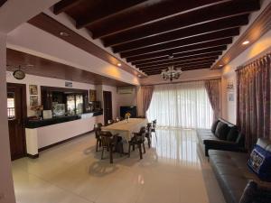 Una sala de estar con una mesa y sillas y un sofá. en Ban Thong U, The Landmark, en Chiang Mai