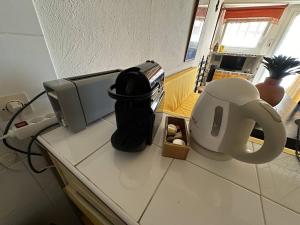 a kitchen counter with a coffee maker and a microwave at Maison de ville sur 2 niveaux - 2 chambres - terrasse tropézienne in Saintes-Maries-de-la-Mer